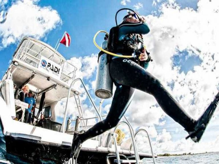 Dive instructor jumping into the ocean